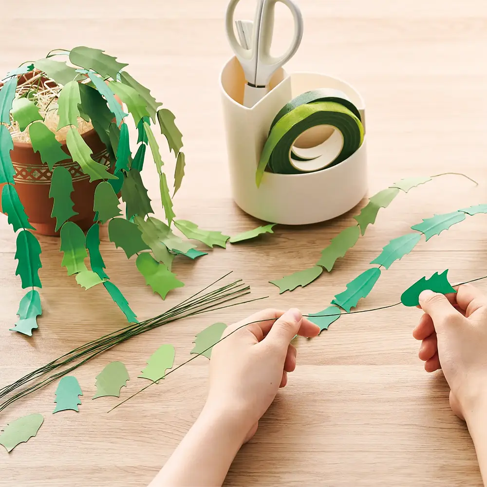 カッティングマシンでカットされた植物のパーツを組み立てている様子