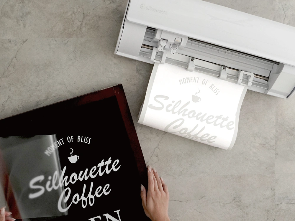 カッティングマシンでステッカーを制作中。立て看板に貼るステッカーの文字がカットされている。