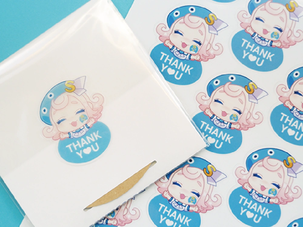 Silhouetteカッティングマシンがステッカーをカットしている場面。キャラクターは女の子とペンギン。