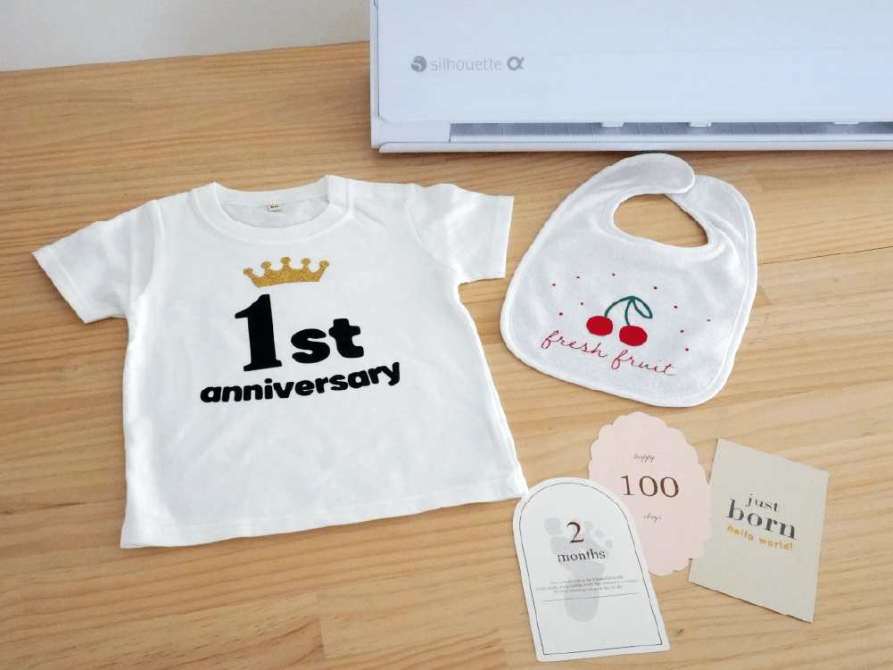 完成したベビー服とスタイ、マンスリーカード